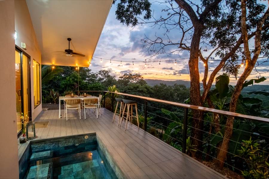 The plunge pool deck at Casa Lunax under string lights at dusk