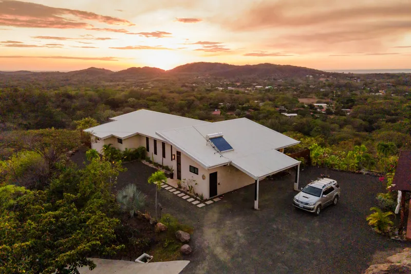 Aerial view of Villa Toltec at sunset, the hills and coastline near Tamarindo beyond