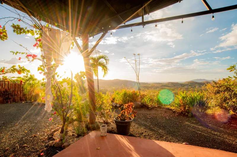 Sun bursting through the open frame of the yoga studio over the valley